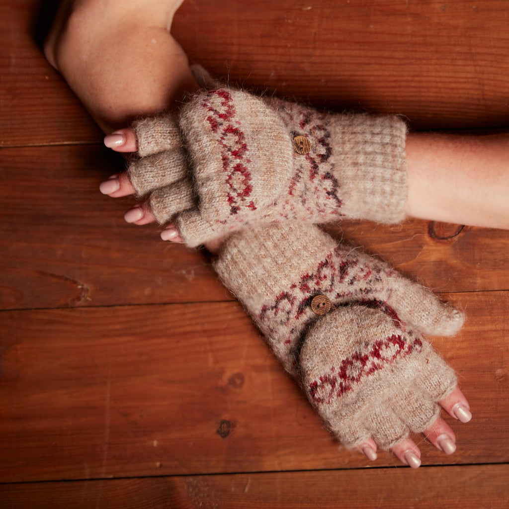Woman's hands wearing fingerless brown gloves with a flip with red heart design.