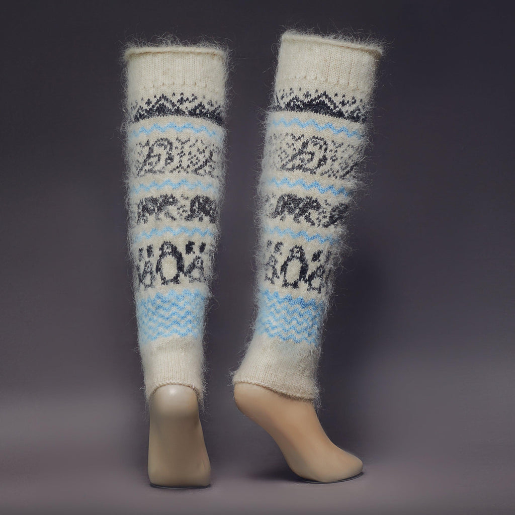Warm, fuzzy goat wool white and blue leg warmers with black mountains, owls, bears, and penguins - back view.