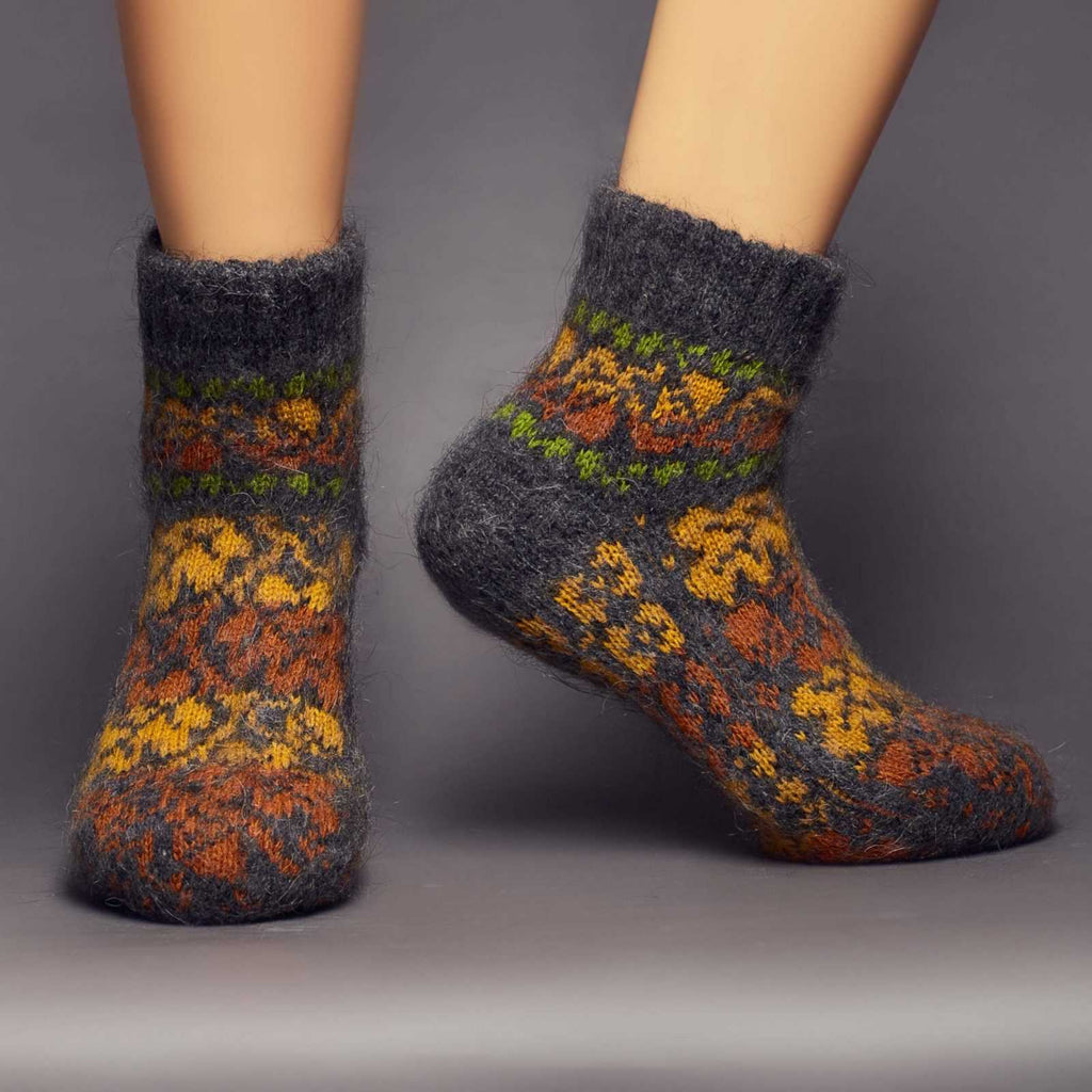 Fuzzy warm goat wool black low-cut socks with yellow-orange fall leaves - front view.