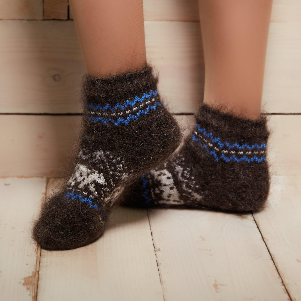 Woman’s legs posing wearing black low-cut warm socks goat hair material, relaxed fit, with a white polar bear design.