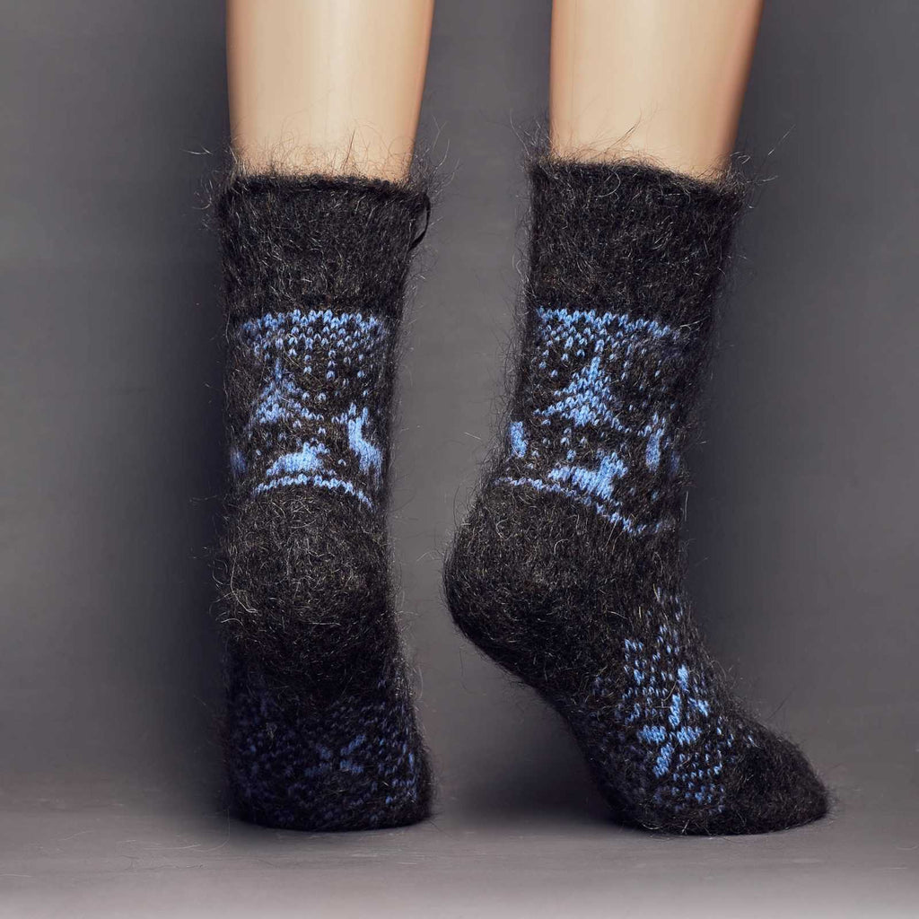 Warm goat wool charcoal crew-length socks with a blue deer, trees, and winter ornaments - back view.
