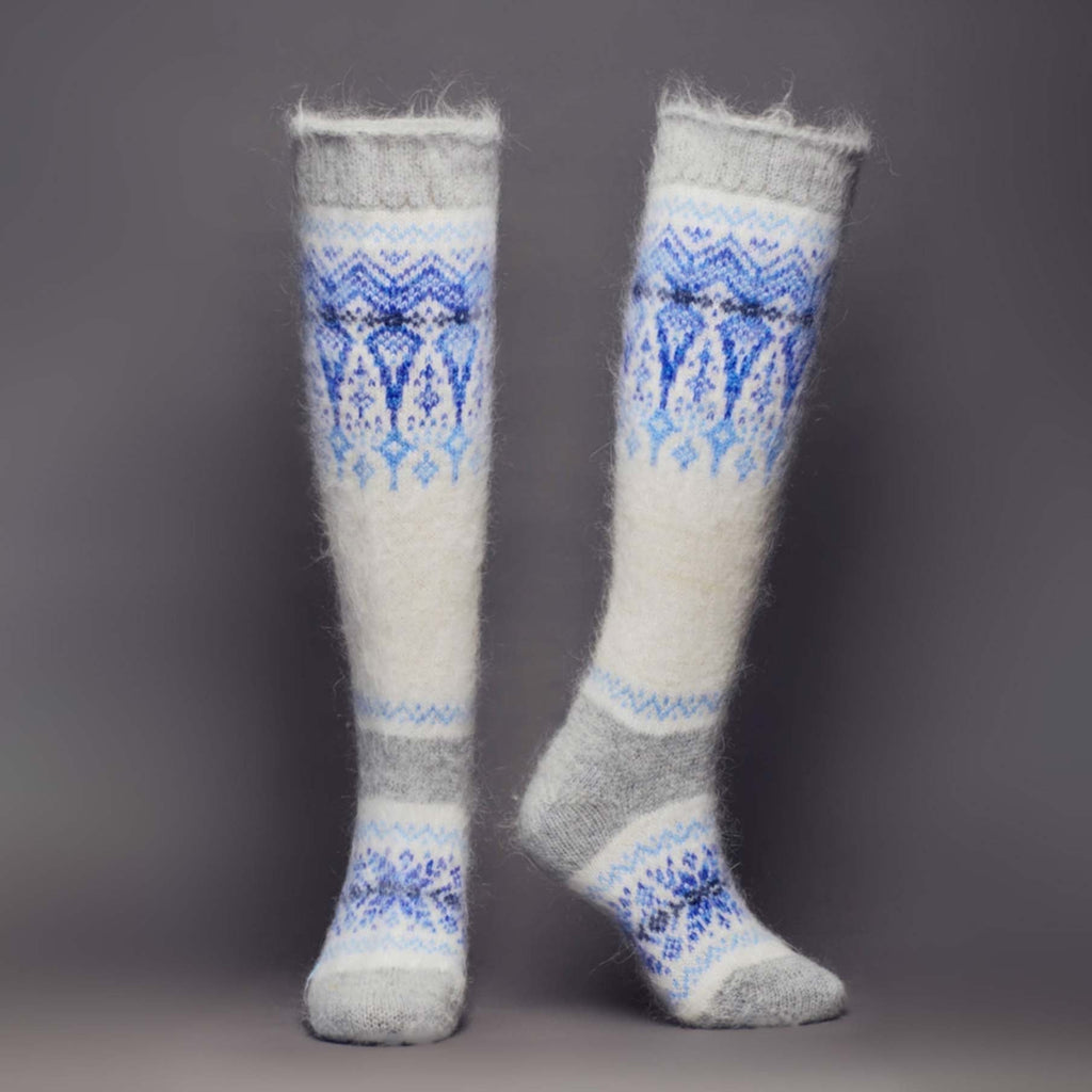 Goat hair white and grey knee-high relaxed fit socks with blue winter ornament - front view.