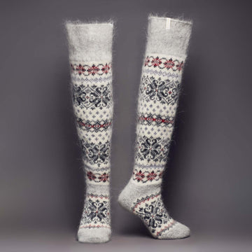 Pair of warm light-grey and white goat hair over-the-knee socks with black and maroon ornaments - front view.