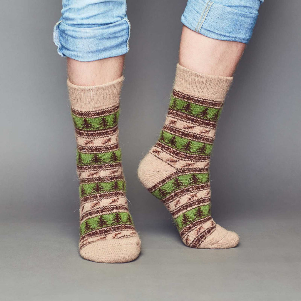 Man’s legs wearing brown and green merino wool crew socks with forest design - front view.