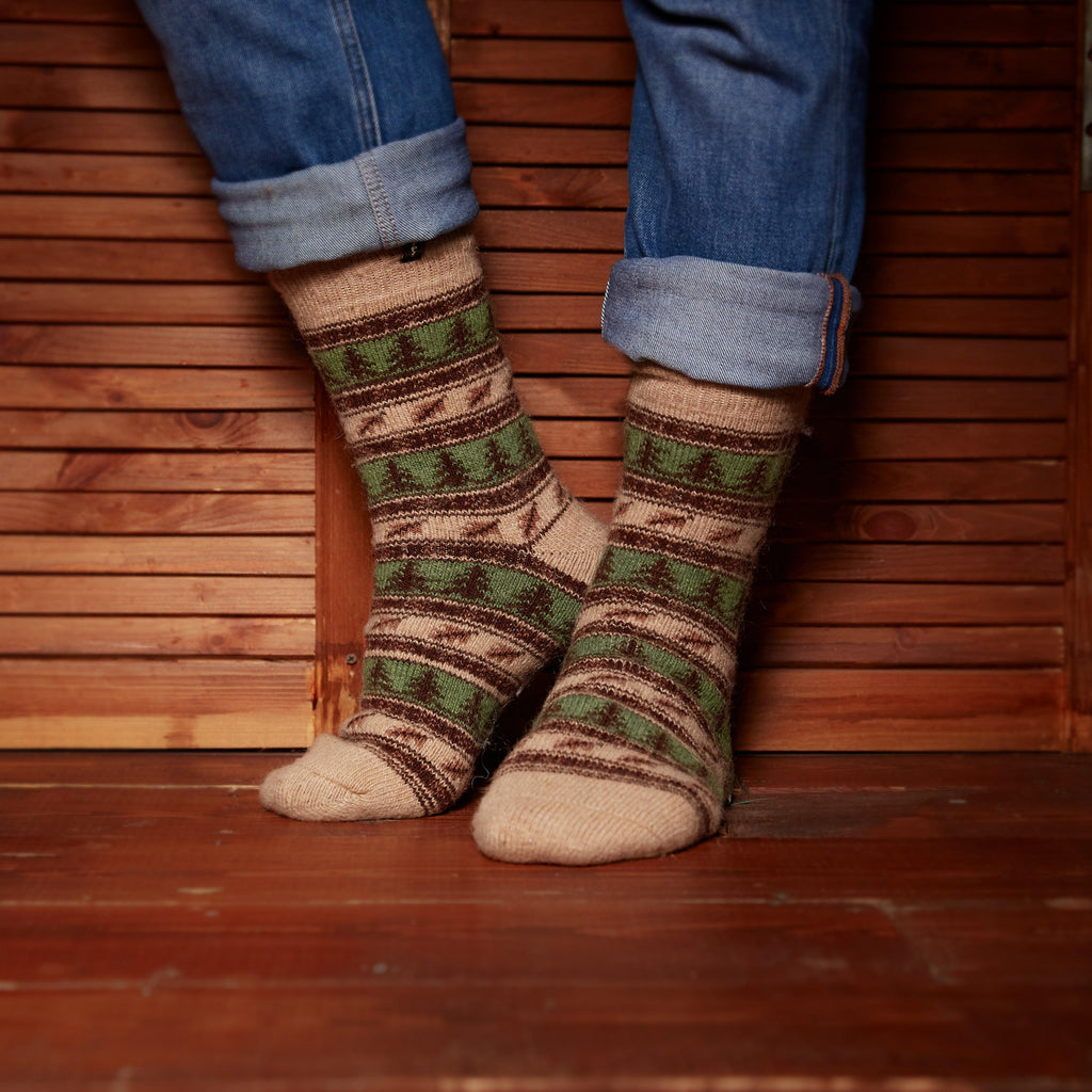 Man’s legs posing in thick wool brown green socks crew length with forest design.