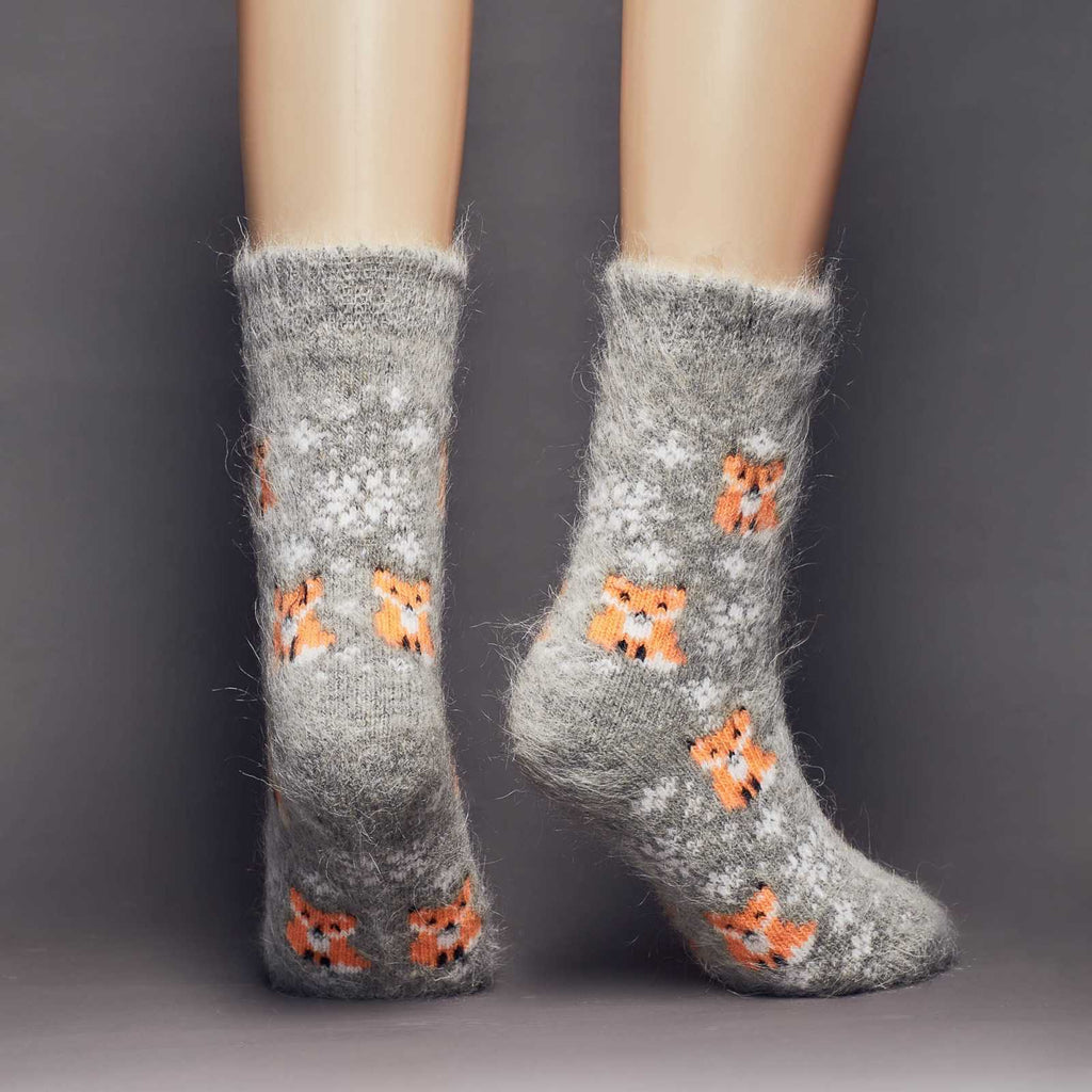 Fuzzy goat wool warm thick crew grey socks with orange foxes and white snowflakes - back view.