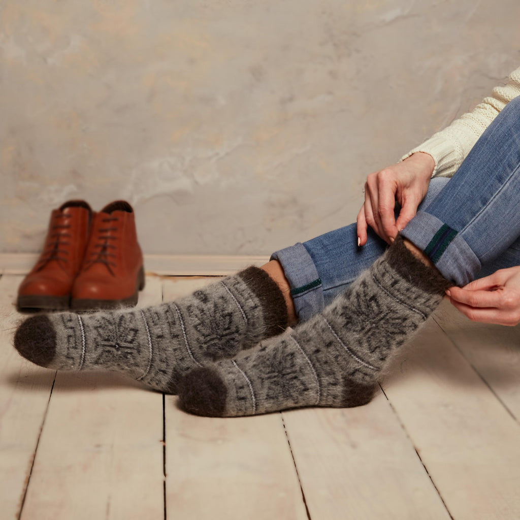 Woman wearing jeans and warm dark grey goat hair thick crew home socks with geometric design
