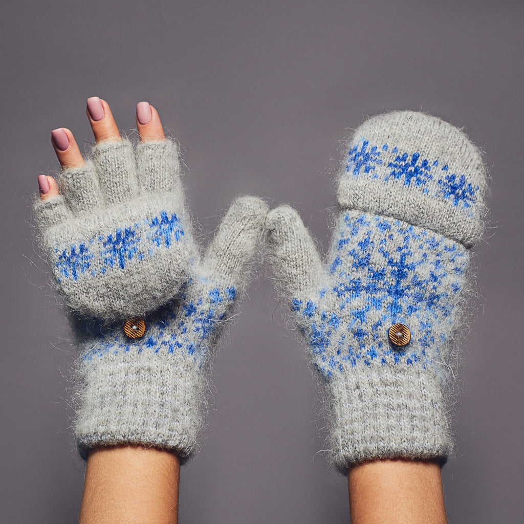 Gray thick fingerless goat hair gloves with a flip with a blue snowflake design.
