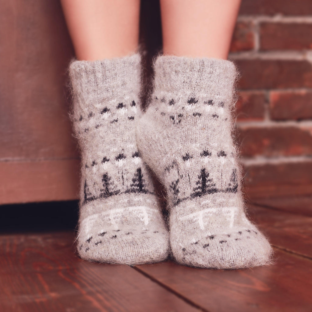 Person’s legs wearing low-cut wool socks a grey with black and white tree design.