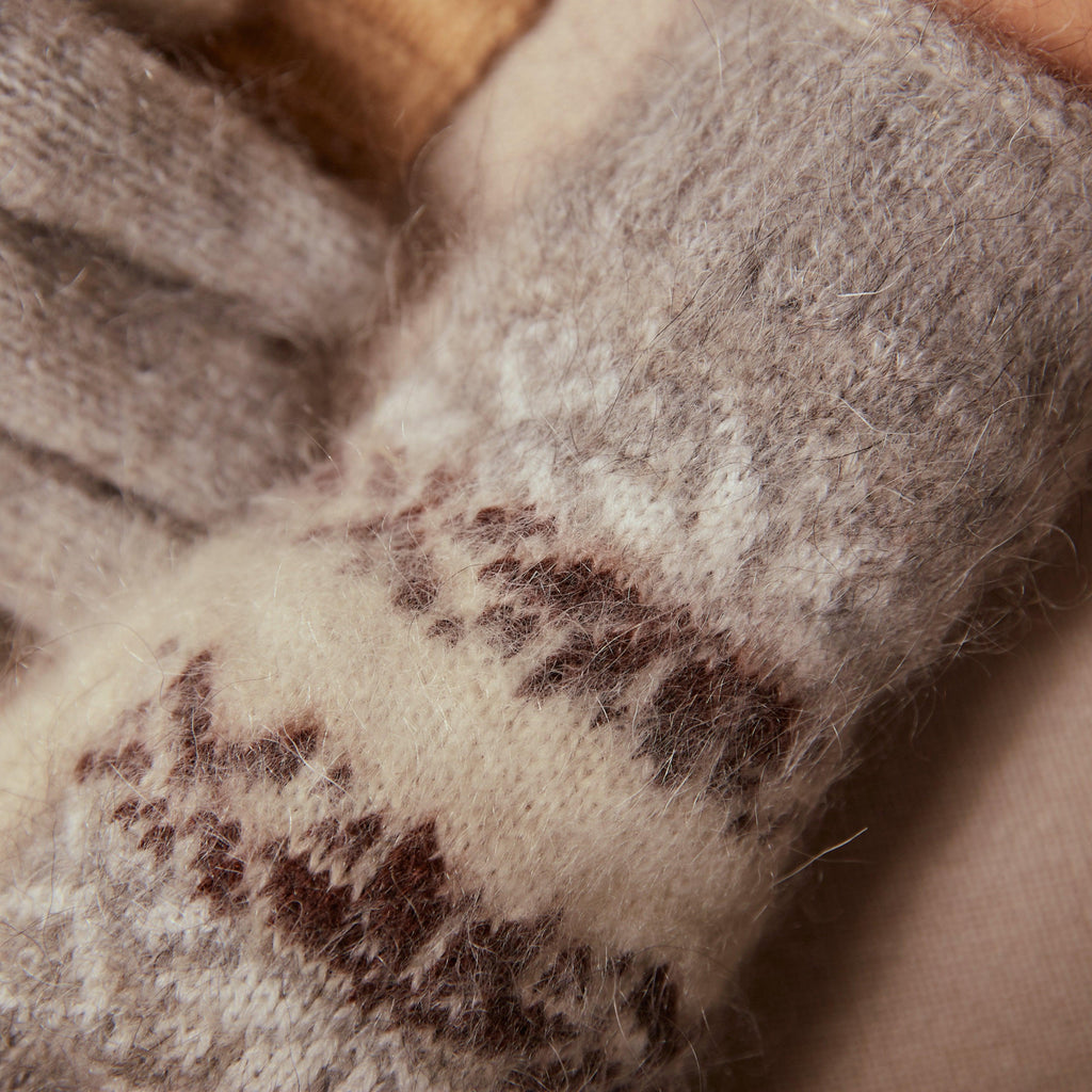 Fuzzy, warm goat wool light-gray and white goat wool gloves with black and white snowflakes.
