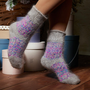 Woman's legs wearing gray no-elastic goat wool socks crew length with multicolor purple, pink, and blue design.