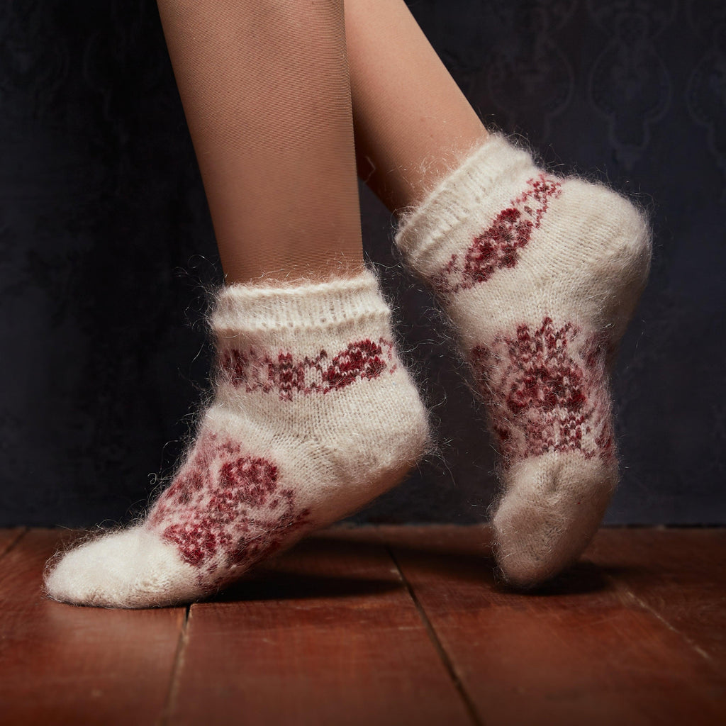 Woman’s legs posing wearing white goat wool socks low-cut length with a red rose pattern.