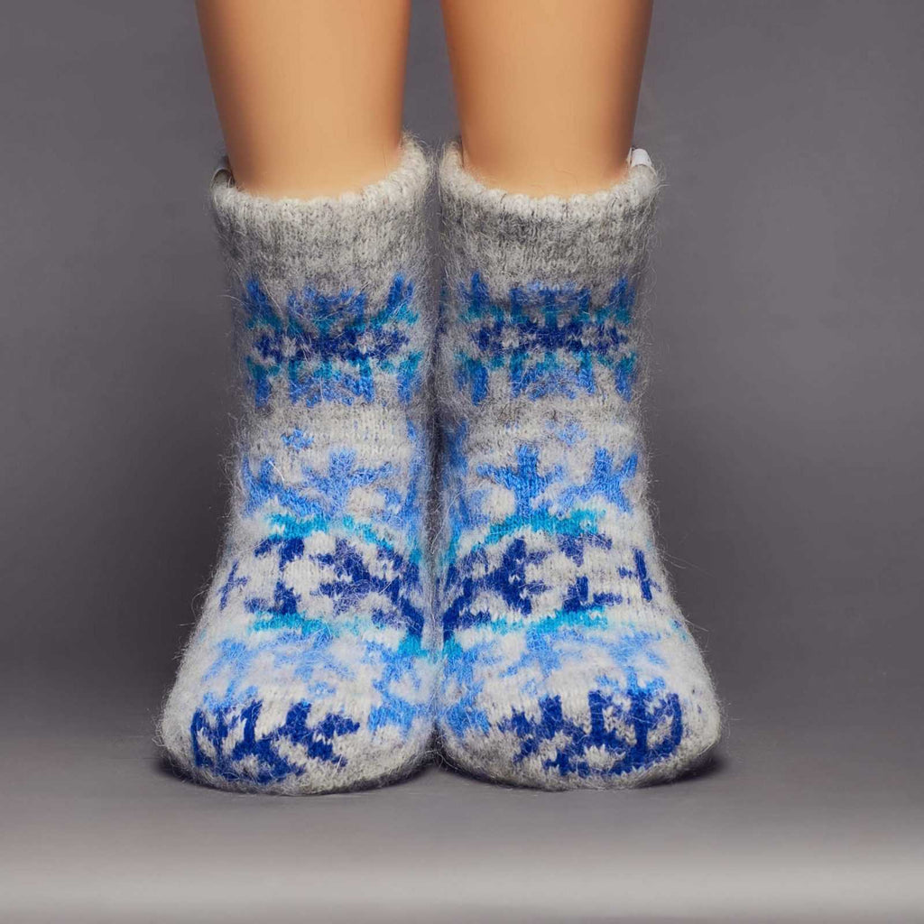 Low-cut grey wool socks with a large blue snowflake design - front view.
