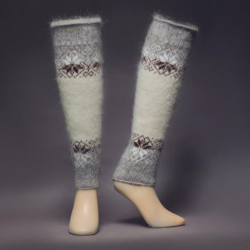 Grey and white goat hair leg warmers with white and dark-brown snowflakes - front view.